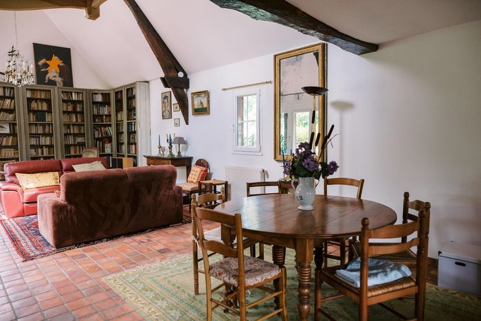 Le séjour-salon de la Maison des Hôtes, bibliothèque et coin repas