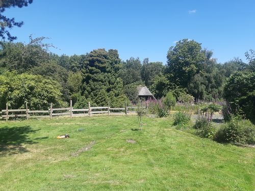 Le gîte, vue sur le jardin et la clôture en bois